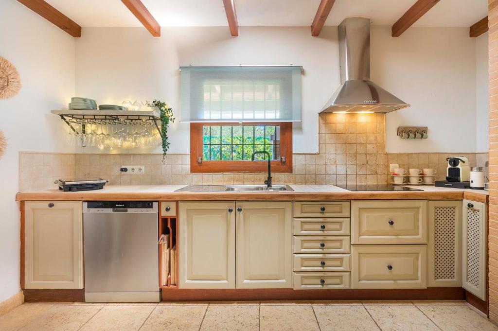 a kitchen with white cabinets and a sink and a window at Can Botanic in Sant Josep de sa Talaia