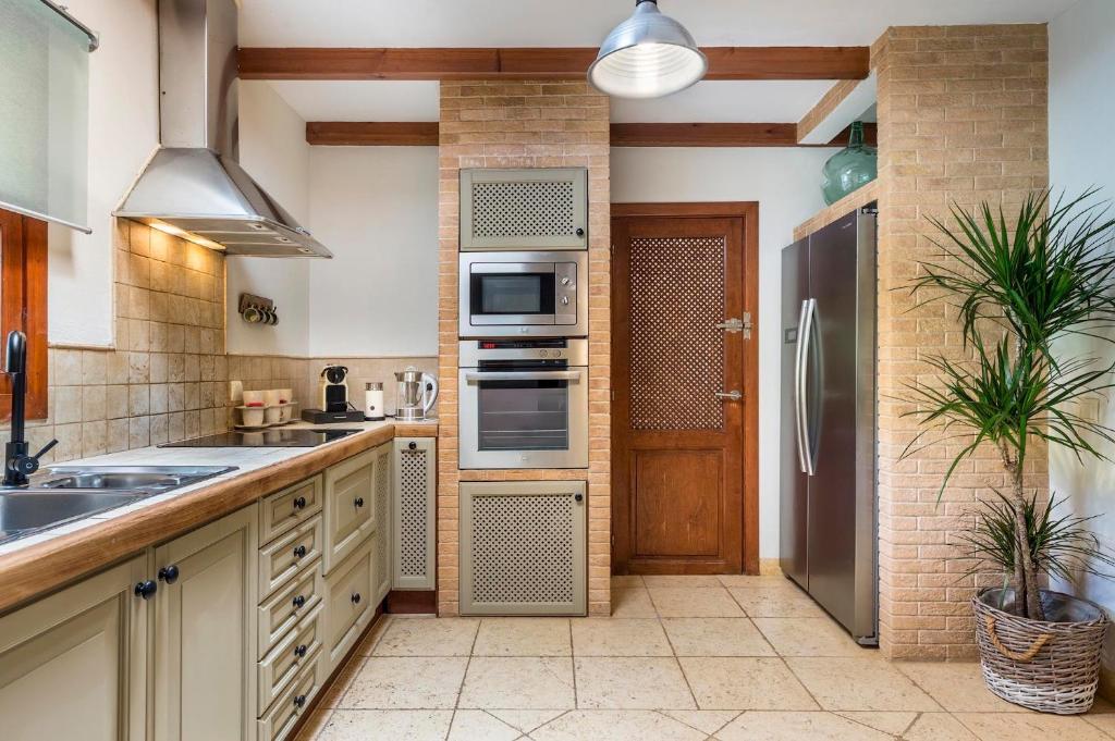 a kitchen with a sink and a refrigerator at Can Botanic in Sant Josep de sa Talaia