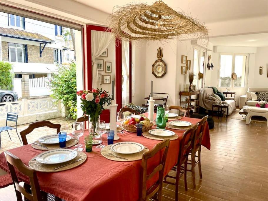 une salle à manger avec une table avec une nappe rouge dans l'établissement Villa Cakine à La Baule, à La Baule