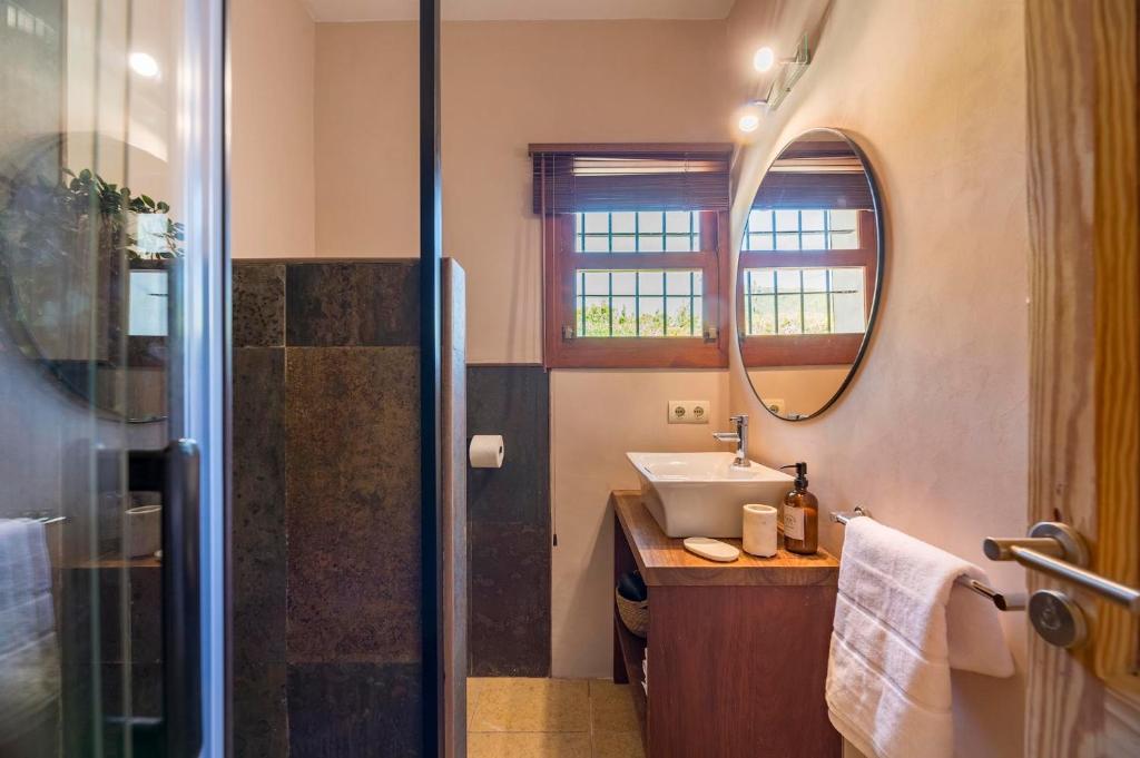 a bathroom with a sink and a shower with a mirror at Can Botanic in Sant Josep de sa Talaia