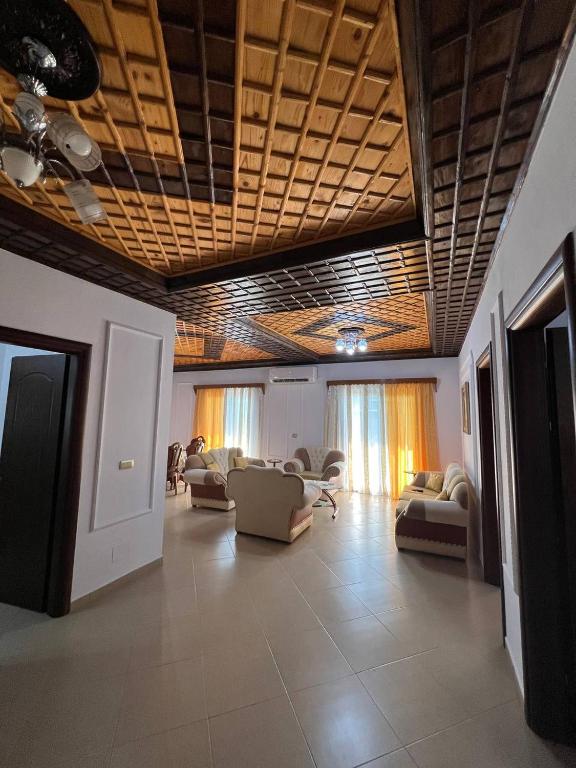 a large living room with couches and chairs at Armando's wooden roof in Berat