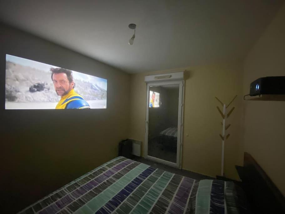 a bedroom with a tv hanging on the wall at Maison 5 pièces jardin in Aubervilliers