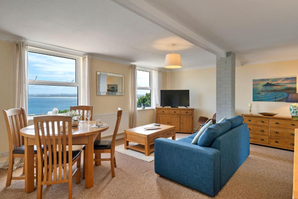 a living room with a table and a blue couch at Finest Retreats - No 11 Porthminster in St Ives