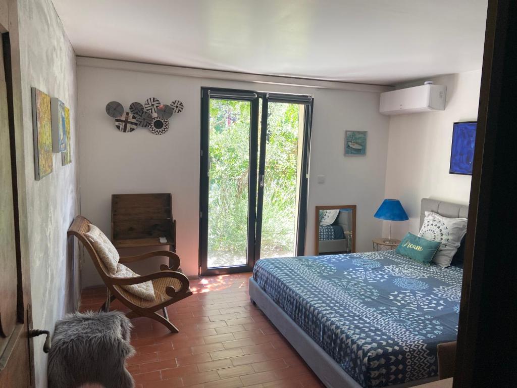 une chambre avec un lit et une porte coulissante en verre dans l'établissement Chambre SUPERIEUR Grand Lit, à Pierrelatte