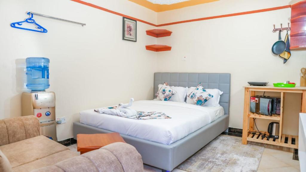 Un dormitorio con una cama, un sofá y una silla. en Studio furnished Apartments Naivasha, en Naivasha