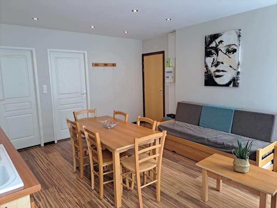 a living room with a table and a couch at Appartement les sources in Plombières-les-Bains