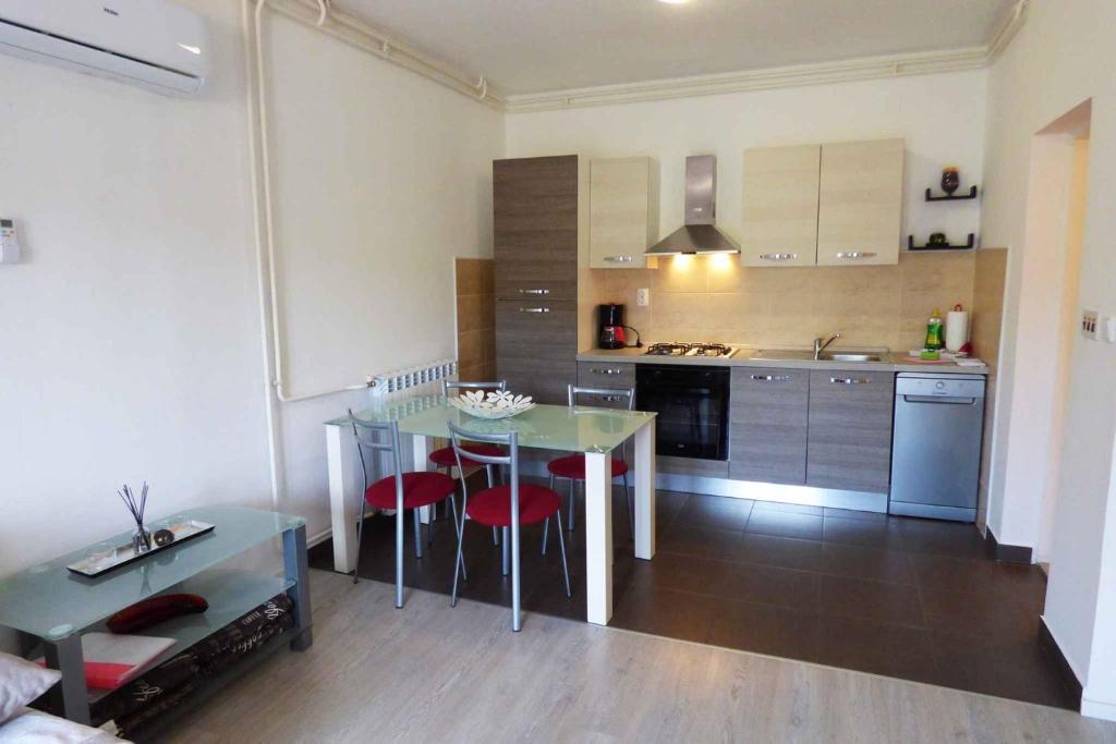 kuchnia ze stołem i krzesłami w pokoju w obiekcie Apartmani Leonardo in Rabaca 36488 w Rabacu