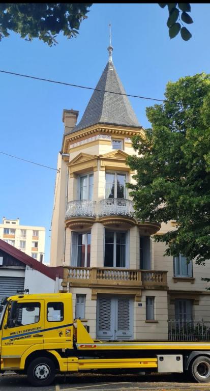 un camion jaune garé devant un bâtiment dans l'établissement Studio climatisé proche CHU, à Saint-Étienne