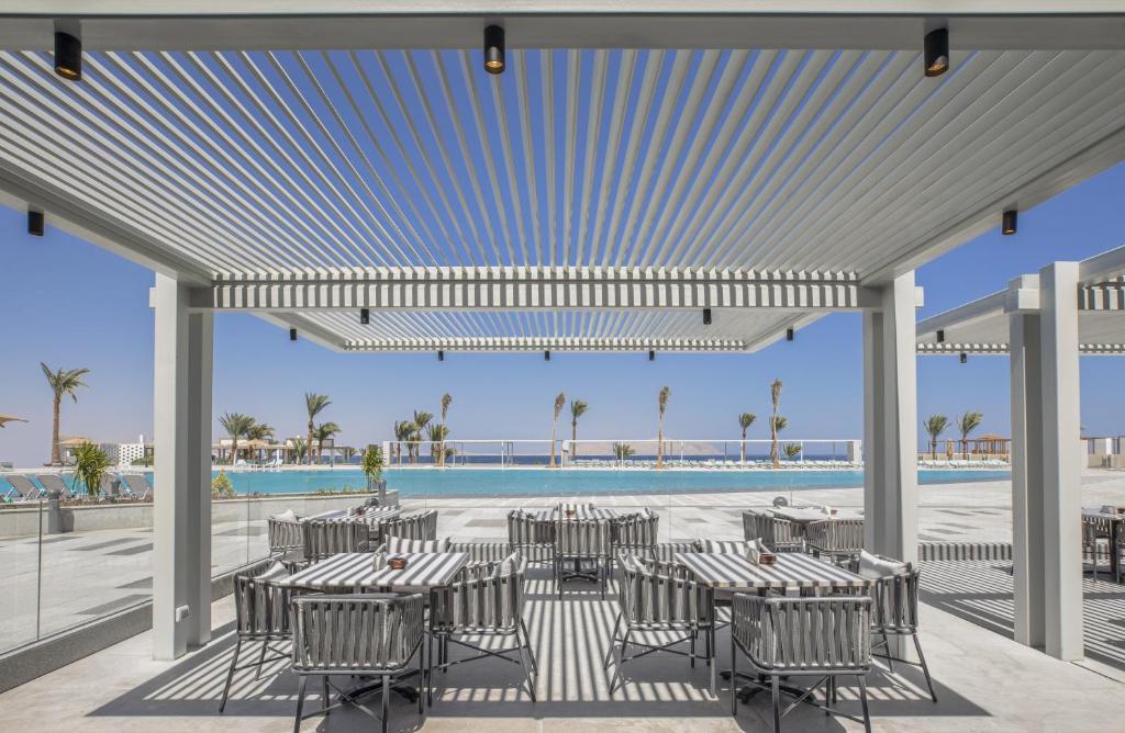 a patio with tables and chairs and a pool at V Hotel Sharm El Shiekh in Sharm El Sheikh