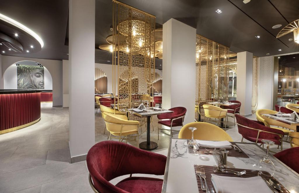 a restaurant with red and yellow chairs and tables at V Hotel Sharm El Shiekh in Sharm El Sheikh
