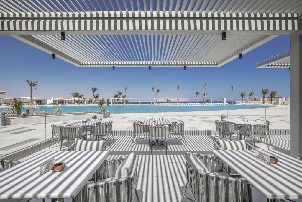 a patio with tables and chairs and a pool at V Hotel Sharm El Shiekh in Sharm El Sheikh