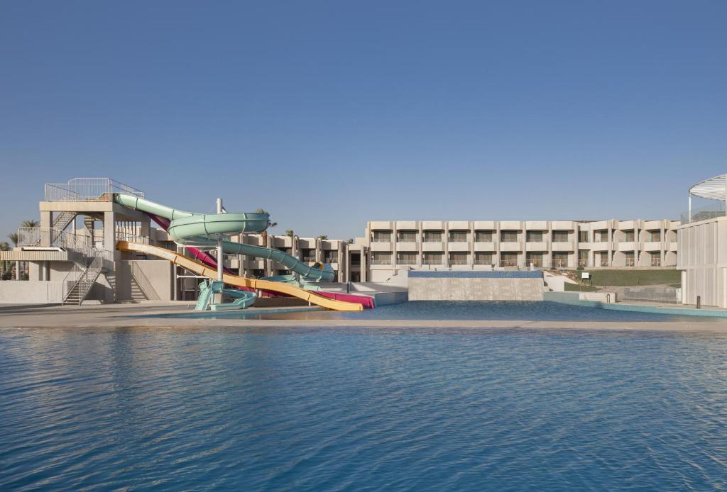 a water slide in front of a building next to the water at V Hotel Sharm El Shiekh in Sharm El Sheikh