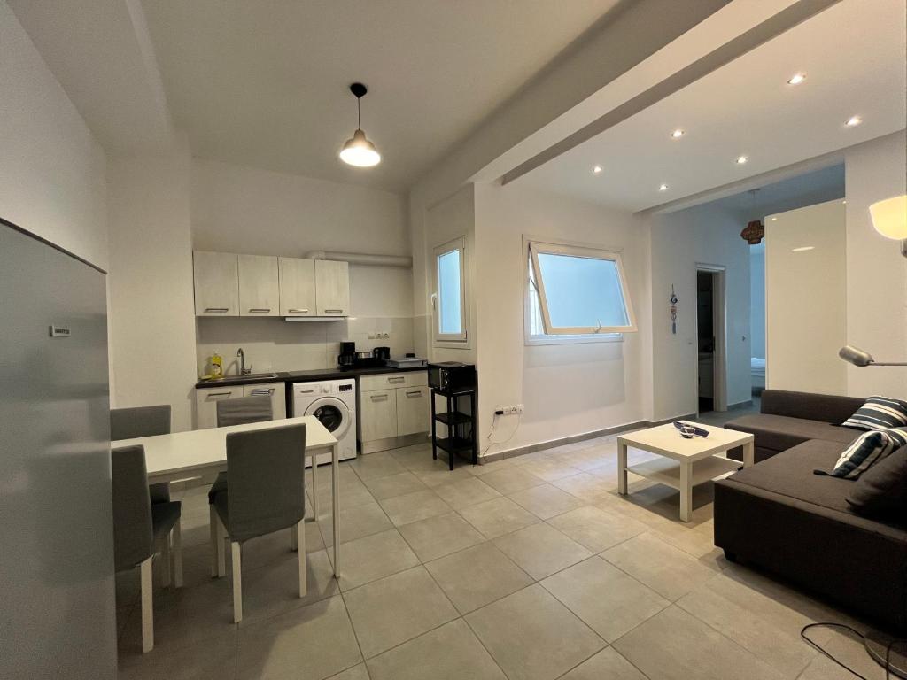a kitchen and living room with a couch and a table at Vibrant Omonia Oasis, Modern Apartment in the Heart of Athens in Athens