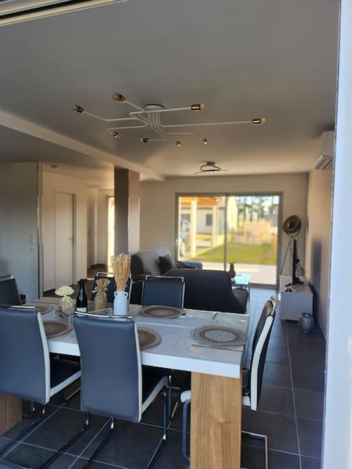 une salle à manger et un salon avec une table et des chaises dans l'établissement Maison cosy jardins et détente, à Montélimar