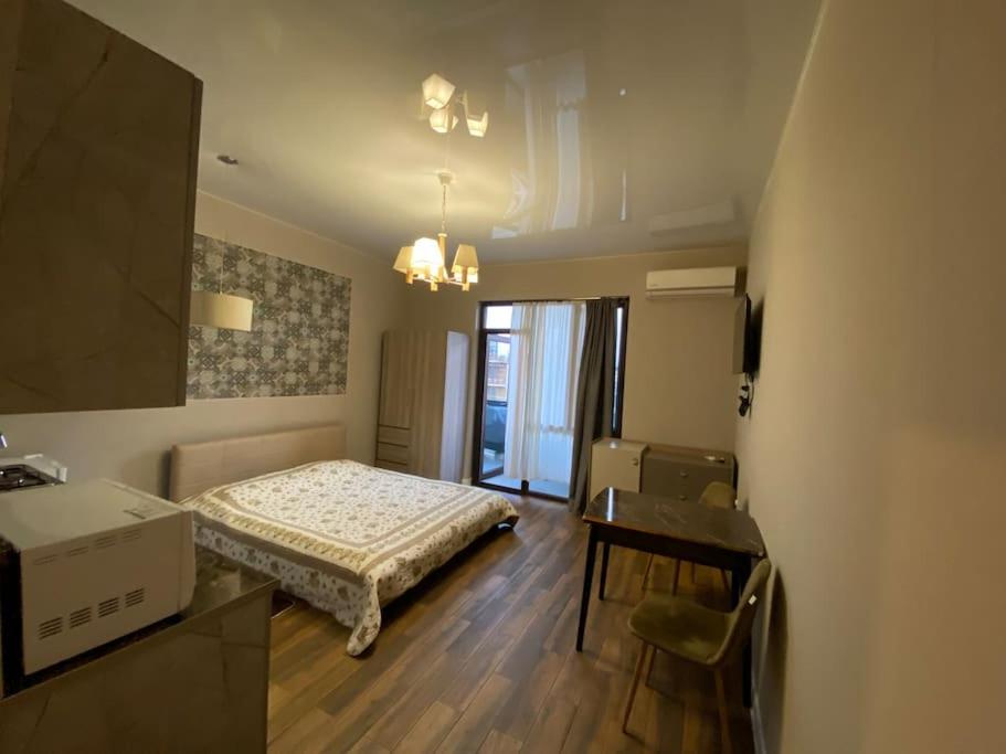 a bedroom with a bed and a table and a desk at Lusi sweet home in Batumi