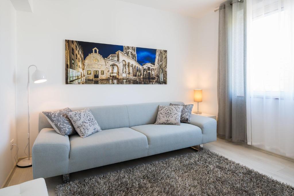 a blue couch in a living room with a painting on the wall at Apartment Sandra with balcony in Split