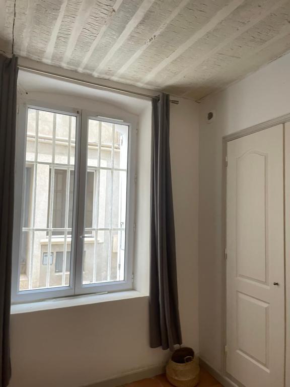 une pièce vide avec une fenêtre et une porte dans l'établissement Studio la ciotat, à La Ciotat