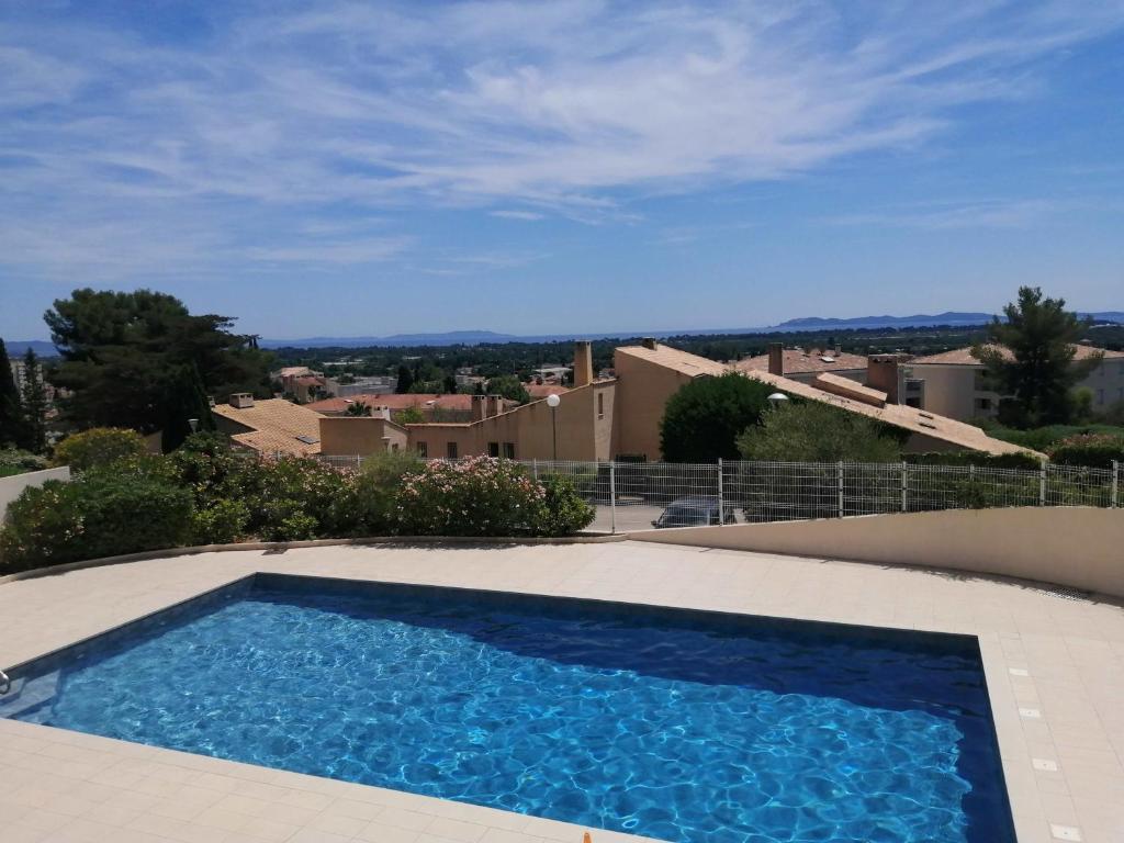 une piscine au sommet d'une maison dans l'établissement Studio climatisé dans résidence avec piscine et tennis, à Hyères