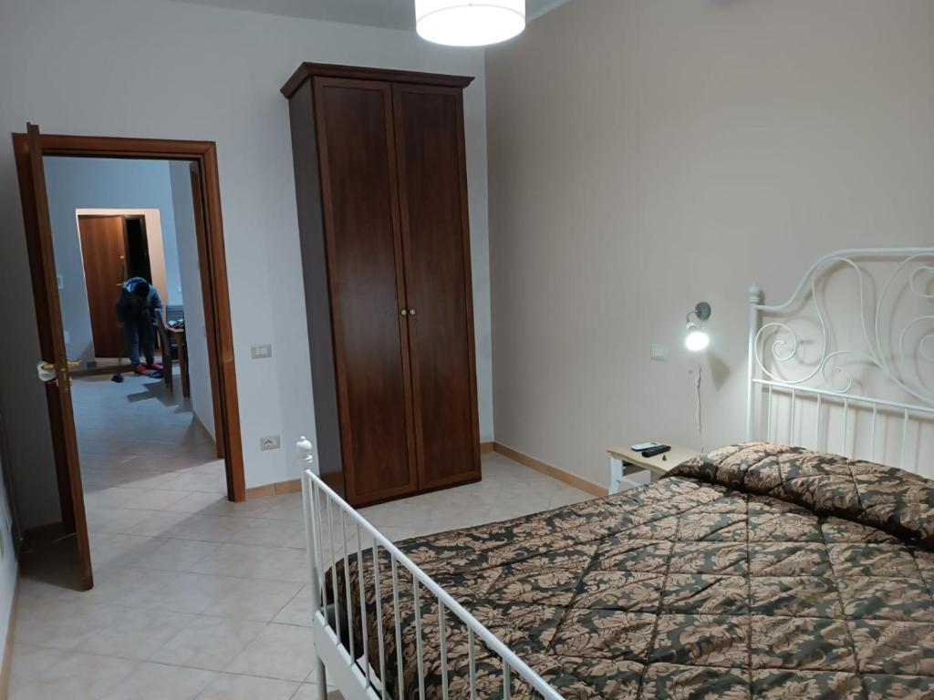 - une chambre avec un lit et un placard en bois dans l'établissement Adriatica 21 zona centrale, à Montalto di Castro