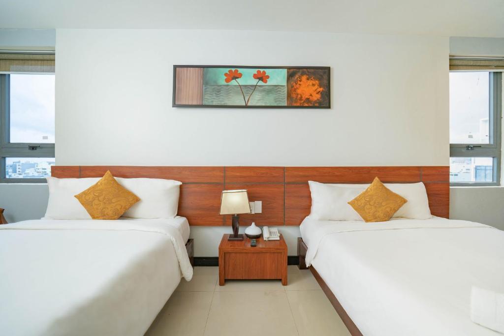 Postel nebo postele na pokoji v ubytování Quoc Cuong Center Da Nang Hotel by Haviland