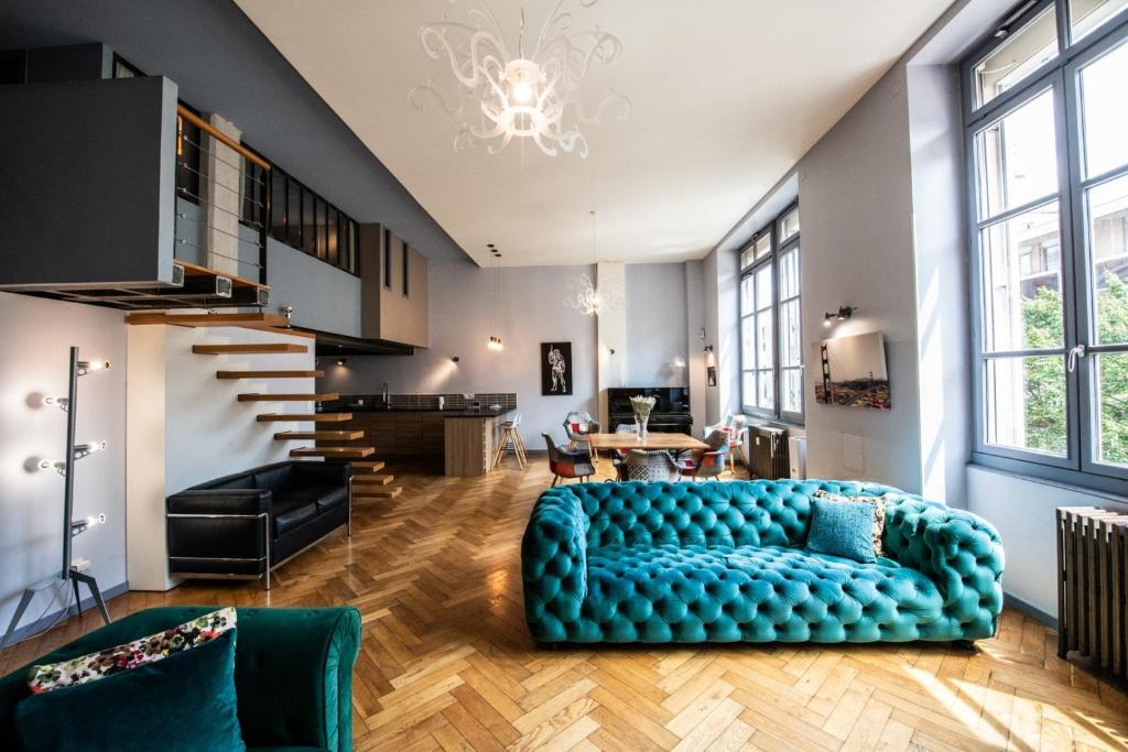 - un salon avec un canapé bleu et un escalier dans l'établissement Loft Créqui - Bel appart spacieux proche Tête d'Or, à Lyon
