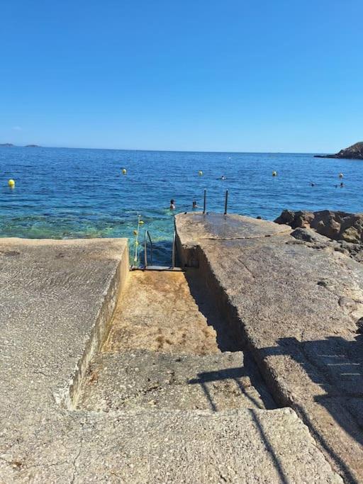 un escalier vers l'océan avec des gens dans l'eau dans l'établissement LE Duplex D'Athéna, à Bandol