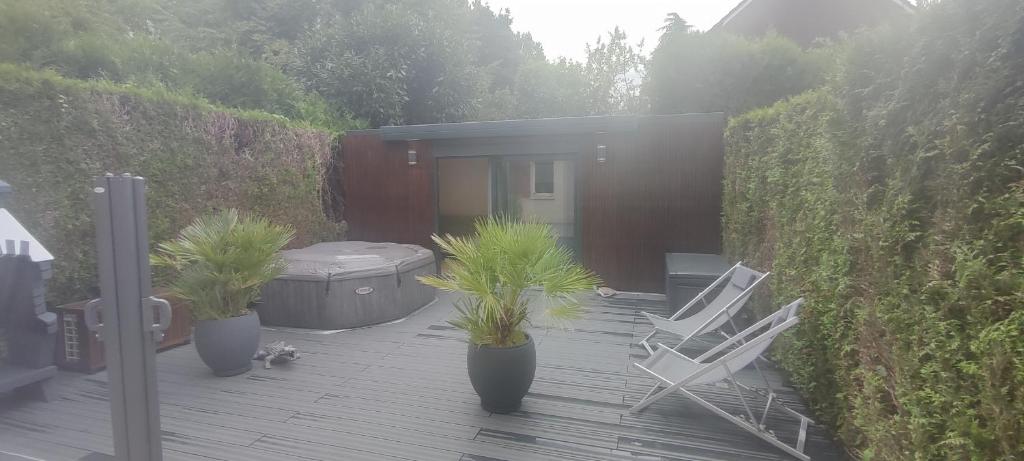 un patio avec deux chaises et un bain à remous et des plantes dans l'établissement Chaleureux Studio, à Pontault-Combault
