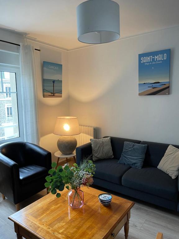 Una sala de estar con un sofá y una mesa de café. en Appart de Manuela, en Saint-Malo