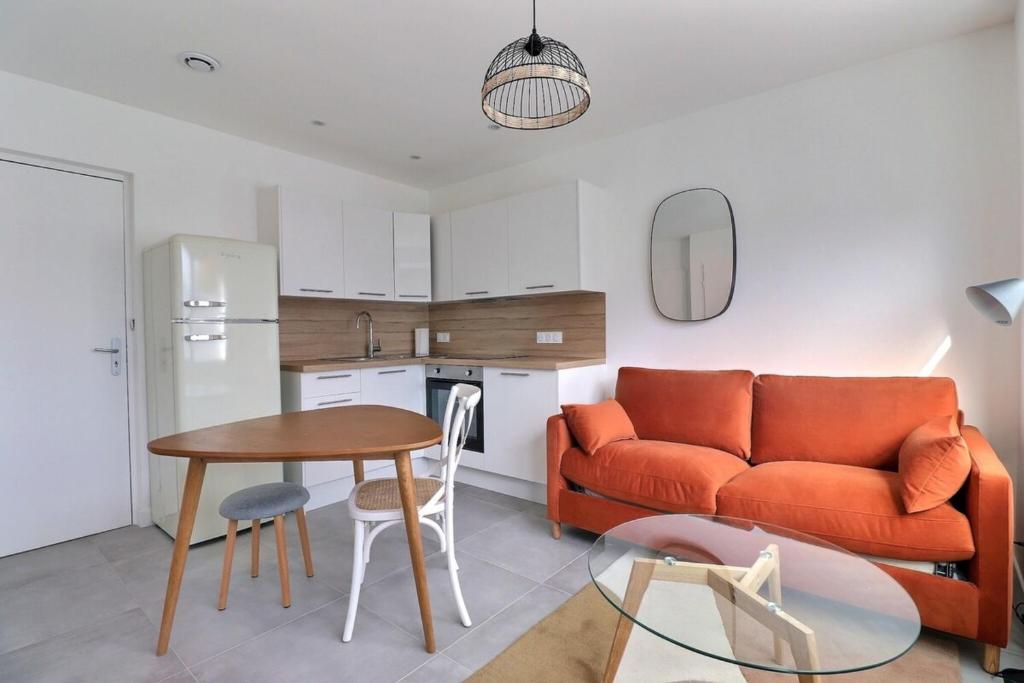 un salon avec un canapé et une table dans l'établissement Les Mimosas - T2 Ground Floor Apartment - Villeurbanne, à Villeurbanne