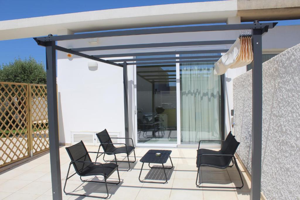 a screened porch with chairs and a table at Casa Marina 44 in Marina di Ragusa