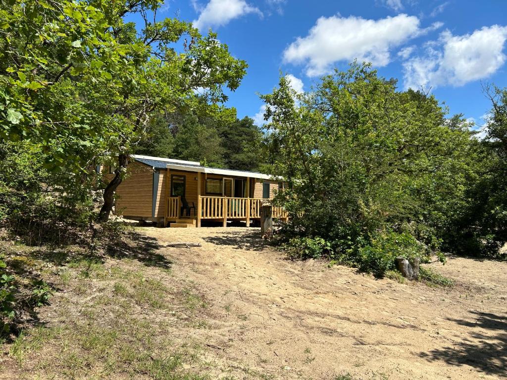 une cabane dans les bois avec des arbres dans l'établissement Mobil home ile de loisirs de buthiers, à Buthiers