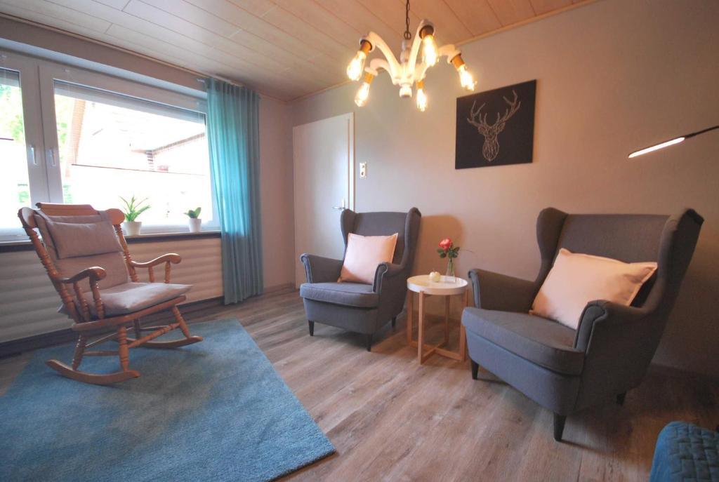 a waiting room with two chairs and a chandelier at Ferienwohnung Kanalblick 35520 in Uplengen