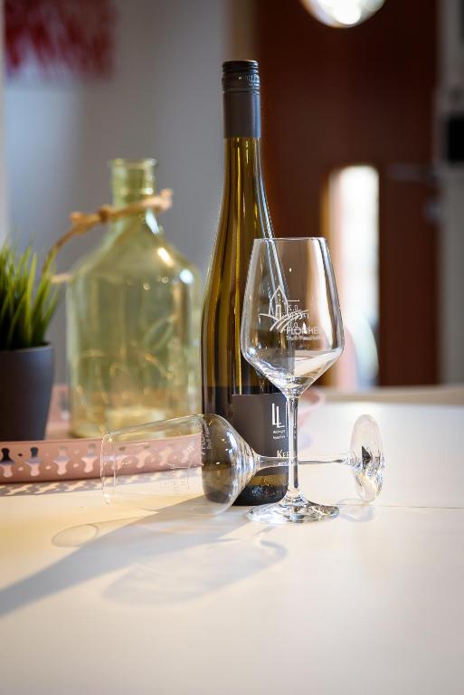 a bottle of wine sitting next to a wine glass at Ferienwohnung Am Backhausgarten in Flonheim