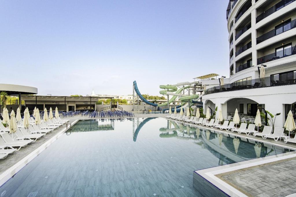 a swimming pool with chairs and a roller coaster at SIDE MOON PALACE in Side