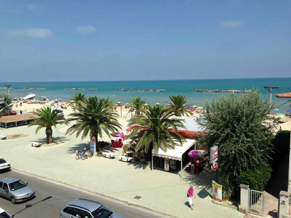 Una vista de una playa con palmeras y el océano en Taverna sul mare, en Francavilla al Mare