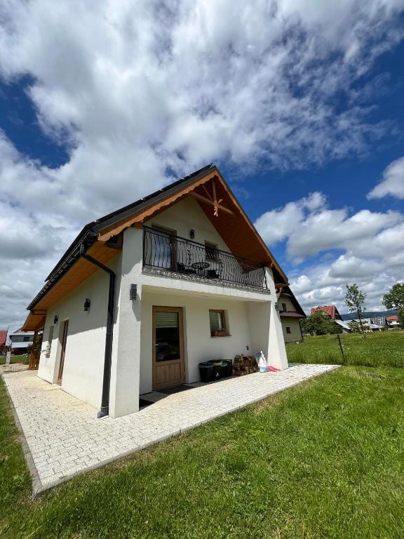 a small white house with a gambrel roof at Apartament Janusza in Gronków