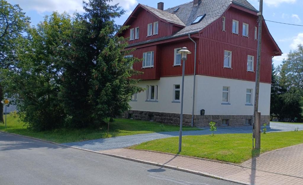 a large red and white house on the side of a street at OK FERIEN - Altes Bahnhaus in Muldenhammer