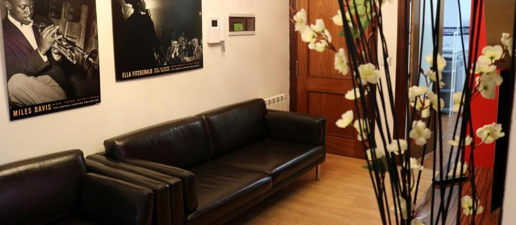 a black leather couch in a living room with pictures at Riojania El Olivo in Calahorra