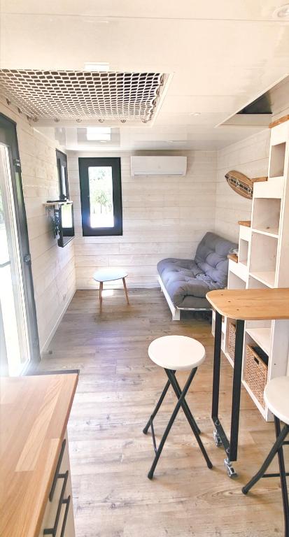 un salon avec un canapé et une table dans l'établissement Tiny House - Mas du Soleil, à Bagnols-sur-Cèze