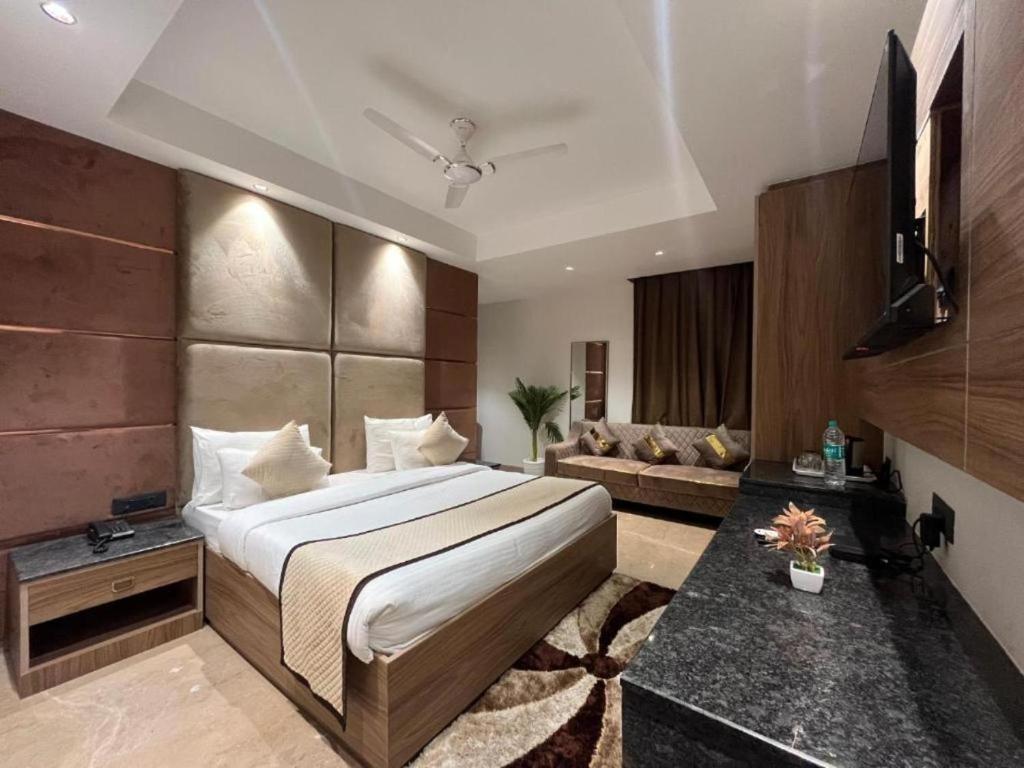 a bedroom with a large bed and a couch at S.N.J LAXMI DHAM in Vrindāvan