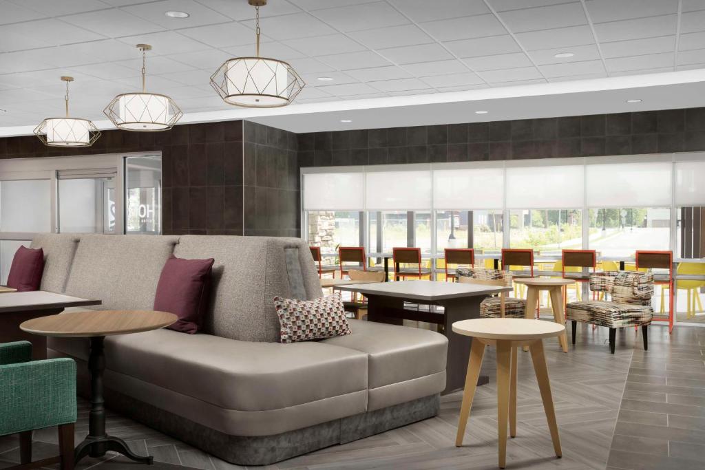 una hall con un divano, tavoli e sedie di Home2 Suites By Hilton Poughkeepsie a Poughkeepsie