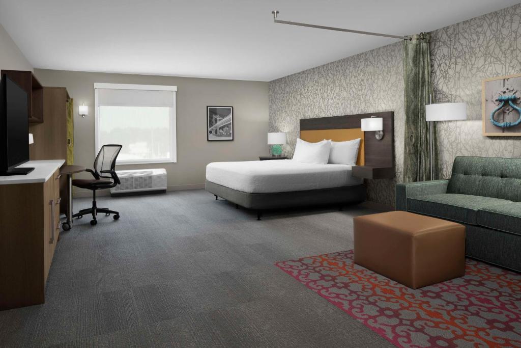 una camera d'albergo con un letto, un divano e una scrivania di Home2 Suites By Hilton Poughkeepsie a Poughkeepsie