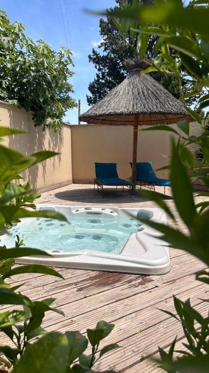 une piscine avec un parasol et deux chaises dans l'établissement Eco logde & spa, à Châteaurenard
