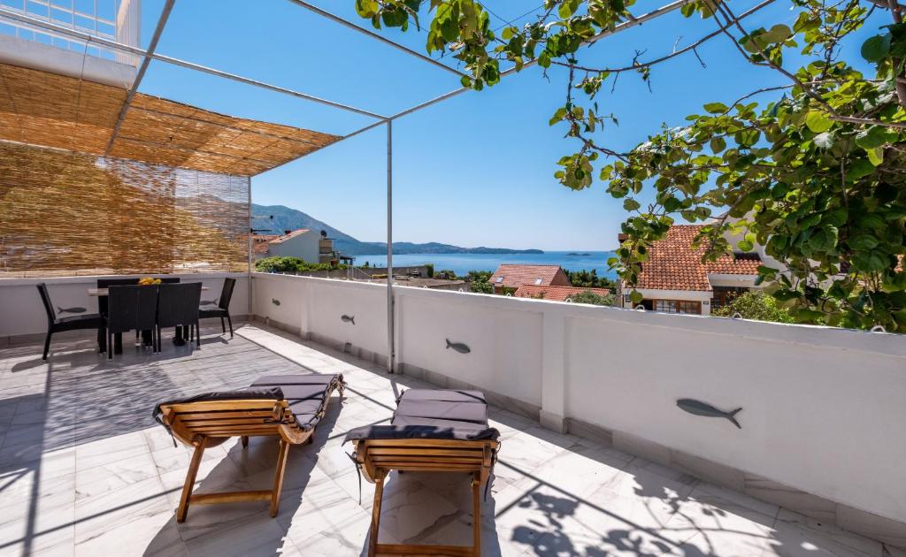 a patio with a table and chairs on a balcony at Lucky Bay - Comfort & Terrace Vibes in Mlini