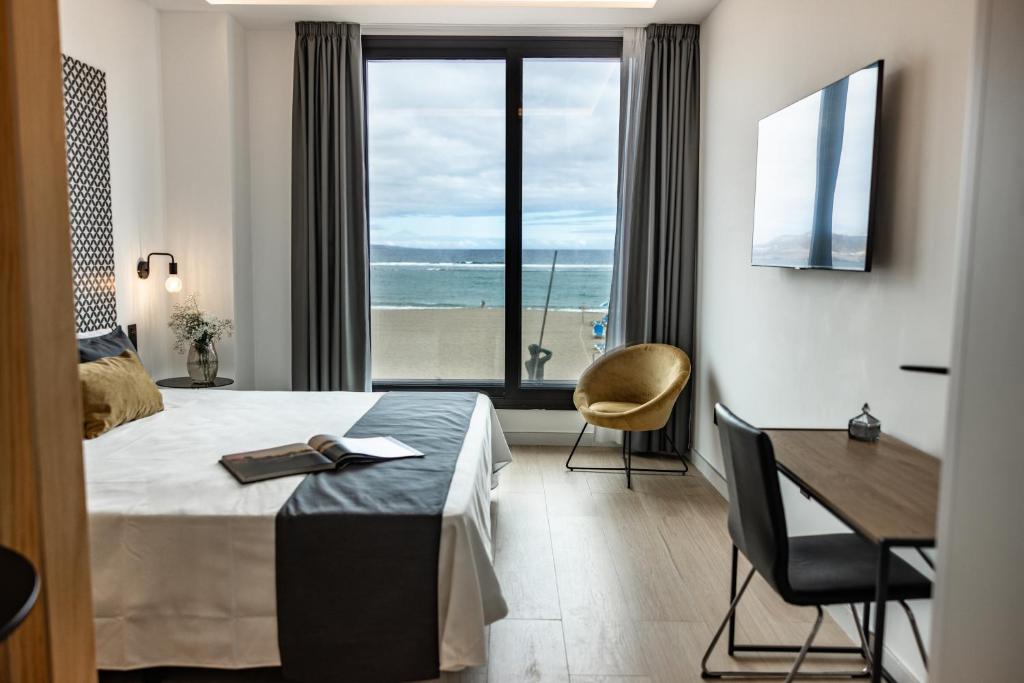une chambre d'hôtel avec un lit, un bureau et une fenêtre dans l'établissement Matilde Luxury by Grupo Matilde, à Las Palmas de Gran Canaria