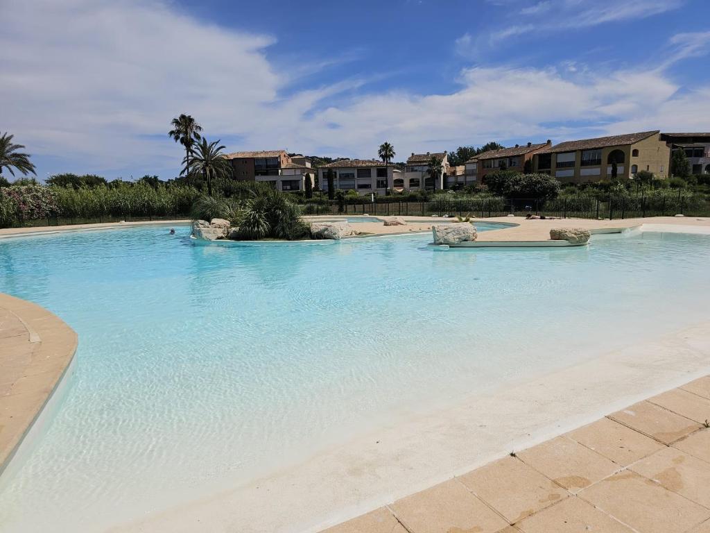 une grande piscine avec de l'eau bleue dans l'établissement Magnifique appartement aux marines de Gassin, à Gassin