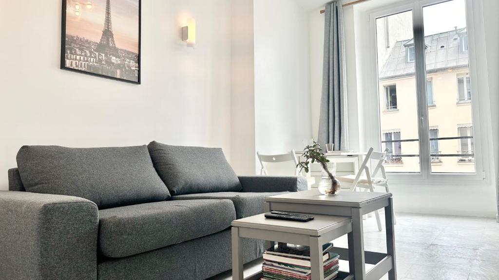 un salon avec un canapé et une table dans l'établissement 117- Charmant Appartement Cosy pour 5 au Cœur de Paris, à Paris