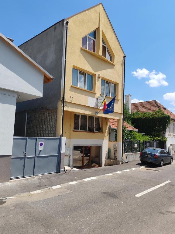 a building with a car parked in front of it at PENSIUNEA HORA in Braşov