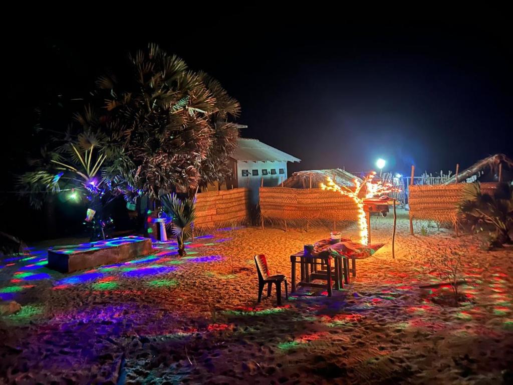Un patio iluminado por la noche con luces de colores. en Delft Jeyam Resorts, en Delft East