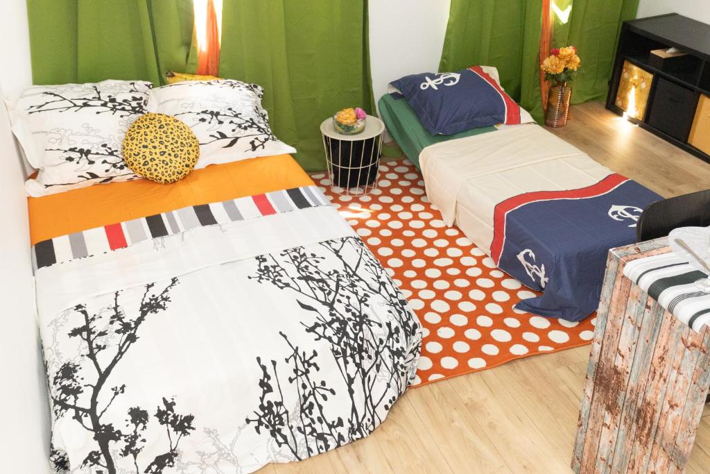 zwei Betten in einem Zimmer mit grünen Vorhängen in der Unterkunft Cloud Nine, 5mins ORLY Airport in Athis-Mons